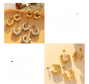 Detail of C-shaped 18K gold plated earrings with pearls and cubic zirconia stones