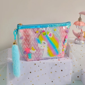Macro detail of rainbow glitter unicorn makeup bag with plush charm and clear PVC texture