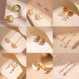 Collection of vintage pearl earrings with tassel and geometric designs in gold