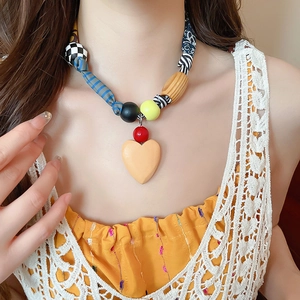 Gros plan d'un collier pendentif cœur bohème avec des perles colorées sur un modèle