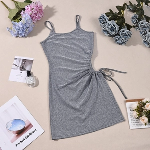 Détail de robe courte à paillettes argentées avec cordon latéral et texture brillante