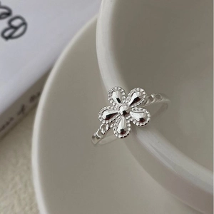 Elegant S925 sterling silver sunflower ring with milgrain petals on a white ceramic cup