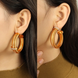 Luxurious gold spiral nail earrings with sparkling crystals for a trendy daily wear look