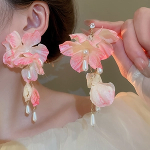 Macro detail of pink fabric flower earrings with pearl tassels and zircon accents