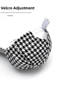 Close-up of the adjustable Velcro strap on a houndstooth pattern baseball cap