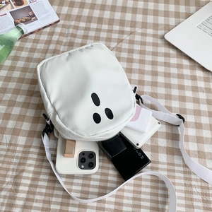 Vue de dessus d'un sac bandoulière blanc montrant sa capacité avec des objets du quotidien
