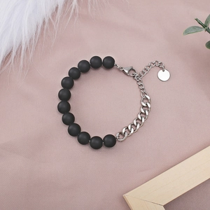 Detail of matte black beads and silver titanium steel curb chain with small round tag