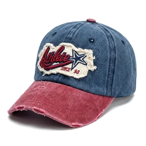 Detail of distressed navy denim baseball cap with vintage athlete patch and worn brim