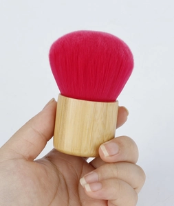 Detailed view of portable bamboo handle powder brush with soft red synthetic bristles