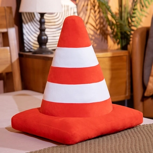 3D plush car tire cushion and orange traffic cone pillow in a cozy home setting