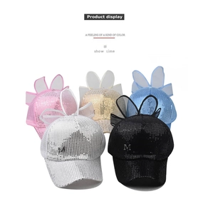 Détail de chapeaux à paillettes avec oreilles de lapin en résille et logo M en métal