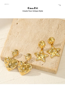 Detail of 14k gold plated heart and star earrings with pavé diamonds on textured stone