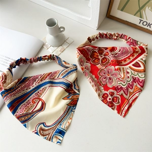 Flat lay of two bohemian silk-feel headbands with floral and paisley prints on white surface