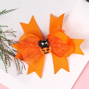 Detail der Halloween Haarspange mit orangefarbener Schleife und Katzen-Kürbis-Motiv