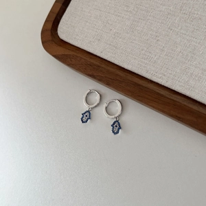 Detailed close-up of S925 sterling silver Hamsa Hand earrings with blue zircon stones