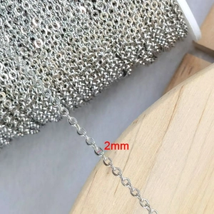 Macro detail of 2mm silver stainless steel cross chain on a rustic wooden background