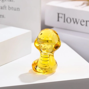 Macro d'une figurine de serpent en verre jaune avec transparence de cristal et fini brillant