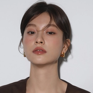 Irregular golden lava fold hoop earrings for women shown on model with metallic finish