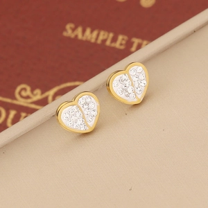 Close-up of golden heart stud earrings with sparkling pavé crystals on beige display