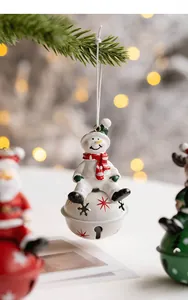 Detail of Christmas snowman bell ornament with red scarf on festive tree background