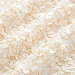 Detailed macro shot of premium cream sequin fabric for elegant evening party skirts