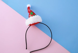 Détail du serre-tête bonnet de Noël à paillettes rouges avec fourrure blanche et houx