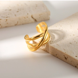 Macro detail of 18K gold-plated multilayer crisscross ring on textured stone base