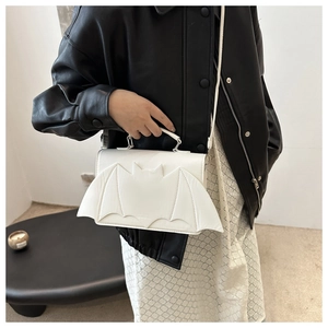Close-up of white bat-shaped shoulder bag with smooth PU leather and top handle