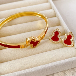 Detailansicht von vergoldetem Schmuckset mit roter Emaille und Zirkon in einer Box