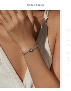 Detail of silver chain bracelet featuring a rectangular clear stone with dark enamel trim