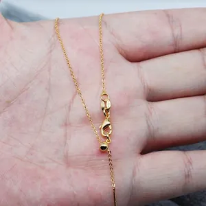Adjustable 18K gold universal chain with lobster clasp and sliding bead on hand