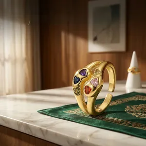 Close-up of golden adjustable ring featuring multi-colored heart zircon stones on marble