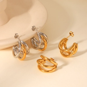 Detail of three-layer intertwined geometric stud earrings in gold and silver finish