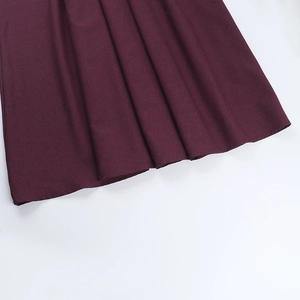 Detailed view of the pleated wine red hemline with premium textured matte fabric