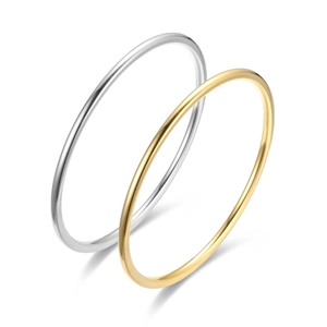 Nahaufnahme von zwei minimalistischen Armreifen aus Titanstahl in Gold und Silber