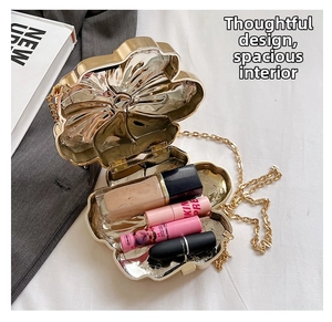 Golden flower-shaped metal chain bag interior showing space for makeup and lipsticks