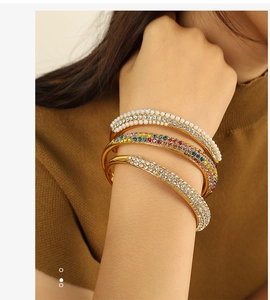 Detailed shot of three gold-plated bangle set featuring white pearls and colorful zircons