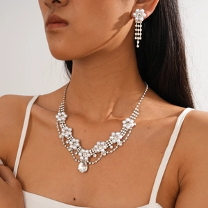 Macro shot of elegant bridal flower jewelry set with pearls and crystal waterdrop pendants