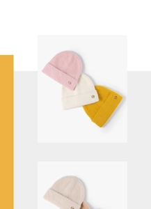 Macro detail of fluffy knit beanie texture with a decorative metallic M logo button