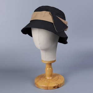 Detail view of cotton bucket hat with contrasting khaki bow on a white model head