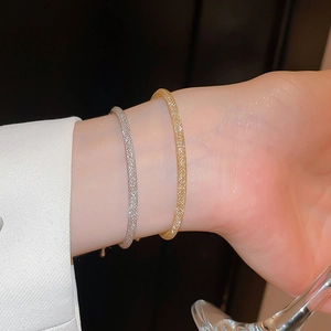 Détail macro de bracelets en maille dorée et argentée avec une texture scintillante