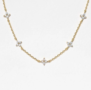 Detail view of a gold clover necklace featuring five charms with micro-pave zircons