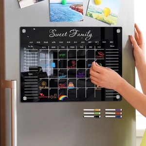 Detailed view of hand writing on a black magnetic acrylic weekly calendar for refrigerators