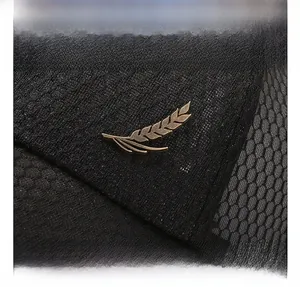 Detail of the bronze wheat stalk metal ornament on a breathable mesh baseball cap