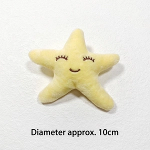 Detail view of a 10cm yellow star plush toy with embroidered smiling face on a white surface