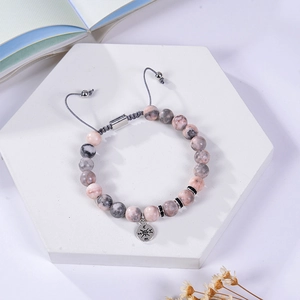 Pink zebra stone beads bracelet with silver compass pendant on a woven cord strap