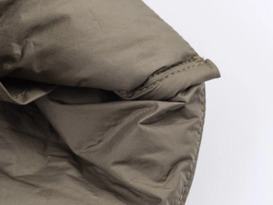 Close-up of olive green padded jacket showing fine stitching and nylon fabric texture
