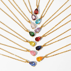 Golden teardrop necklaces with colorful birthstone pendants arranged on a white background