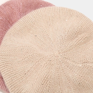 Detail of sequin knit berets in soft pink and beige with fuzzy mohair texture