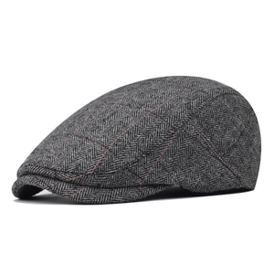 Detail view of gray herringbone tweed flat cap with subtle red and black grid pattern